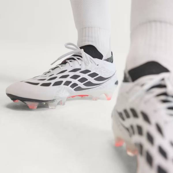 Близки план на бели футболни бутонки adidas Predator с ярки розово-червени ивици,